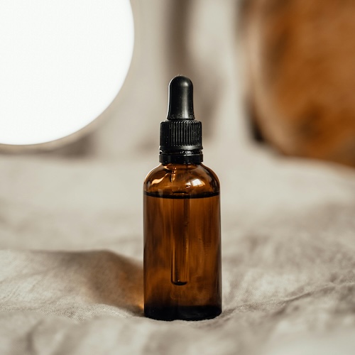 Cosmetic serum bottle on plush background