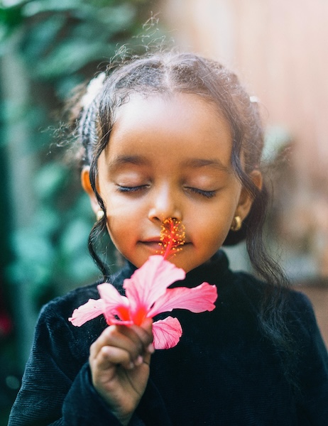 Girl smelling flower 600x450
